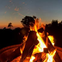 Group storytelling and roasting marshmallows by bonfire
